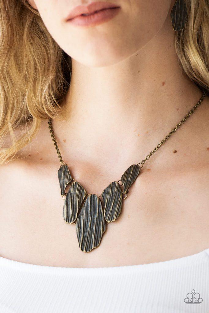 Engraved in antiqued textures, asymmetrical brass plates link below the collar for an edgy look. Features an adjustable clasp closure.  Sold as one individual necklace. Includes one pair of matching earrings.