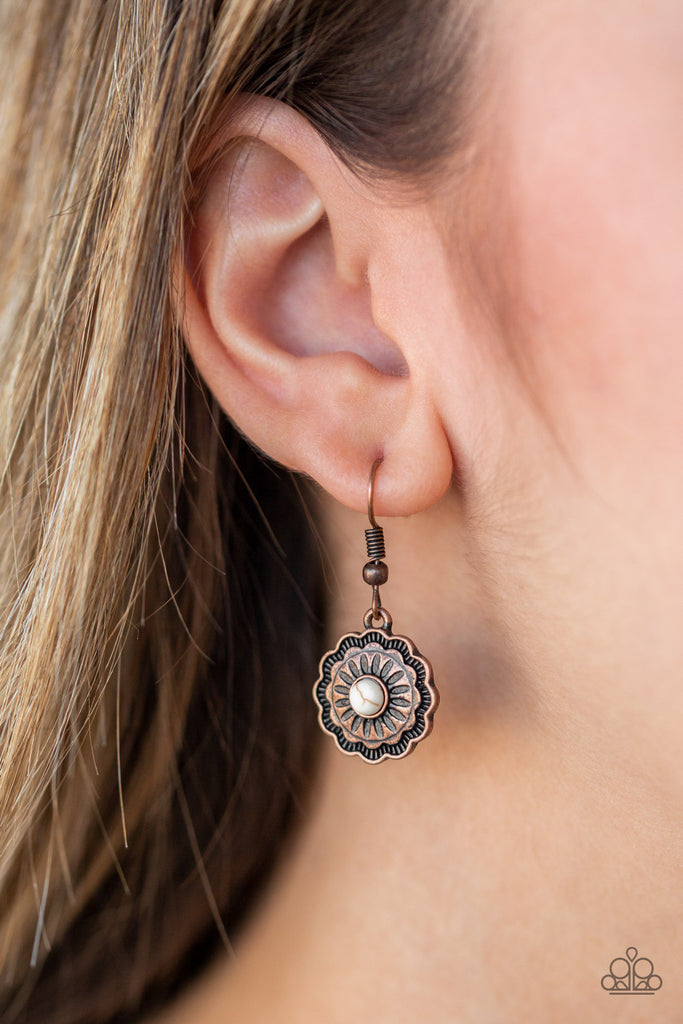 A white stone is pressed into a shimmery copper floral frame radiating with antiqued textures for a seasonal flair. Earring attaches to a standard fishhook fitting.  Sold as one pair of earrings.