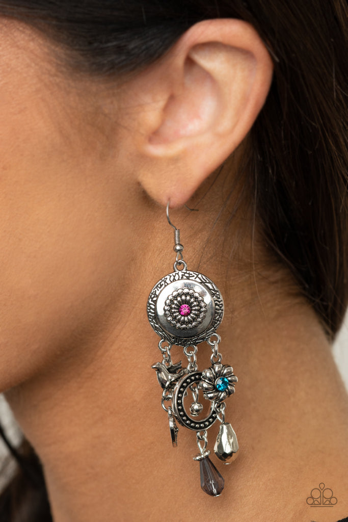 Infused with glittery pink and blue rhinestone and smoky crystal-like accents, a whimsical display of silver heart, flower, and bird charms dance from the bottom of a decorative floral silver frame, creating a noisy fringe. Earring attaches to a standard fishhook fitting.  Sold as one pair of earrings.