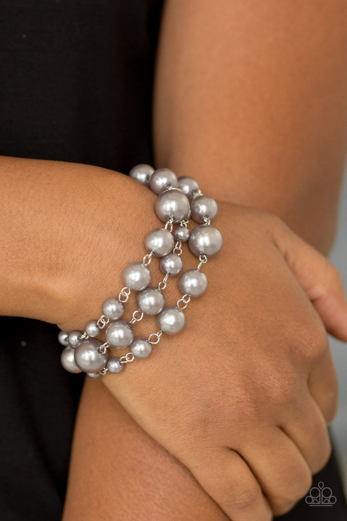 Varying in size, classic silver pearls link around the wrist creating three strands for a timelessly layered look. Features an adjustable clasp closure.  Sold as one individual bracelet.
