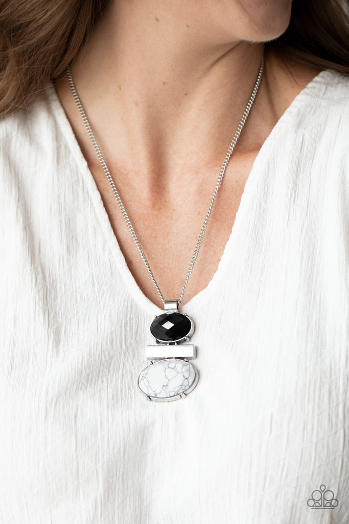 An oval black acrylic bead, shimmery silver rectangular frame, and white stone bead coalesce into a stacked pendant at the bottom of a shiny silver chain for a colorfully earthy look. Features an adjustable clasp closure.  Sold as one individual necklace. Includes one pair of matching earrings.
