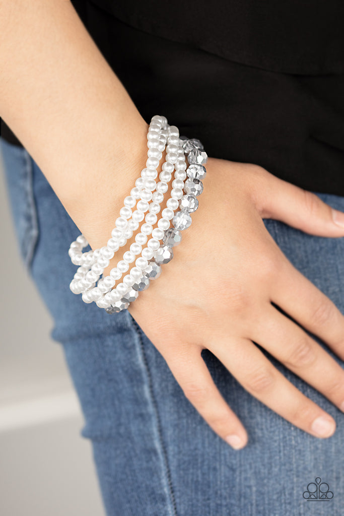 Strands of classic white pearls and metallic crystal-like beads are threaded along an invisible wire around the wrist, creating refined layers. Features an adjustable clasp closure.  Sold as one individual bracelet.