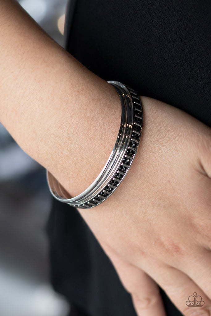 Two classic silver bangles join a thick silver bangle that has been encrusted in pairs of dainty black rhinestones and rectangular silver beading for an edgy refinement.  Sold as one set of three bracelets.  