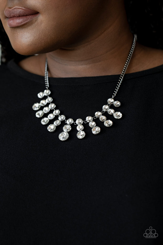 Glittery stacks of glassy white rhinestones gradually increase in size as they drip from the bottom of a classic gunmetal chain, creating a blinding fringe below the collar. Features an adjustable clasp closure.  Sold as one individual necklace. Includes one pair of matching earrings.