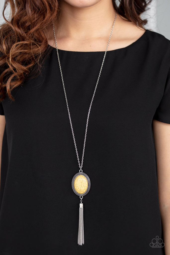 A sunny yellow stone is pressed into the center of an oval silver frame dotted in studded textures. Infused with a whimsical silver tassel, the earthy pendant swings from the bottom of a lengthened silver chain for a seasonal look. Features an adjustable clasp closure.  Sold as one individual necklace. Includes one pair of matching earrings.