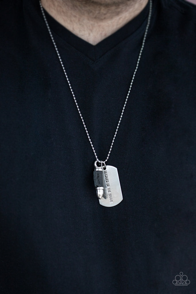 proud-patriot-black Pinched between a black leather fitting, a silver bullet pendant joins a silver dog tag at the bottom of a silver ball chain. The shimmery dog tag is stamped in the phrase, "Because of the Brave," for a patriotic finish. Features a ball and clasp closure.  Sold as one individual necklace.