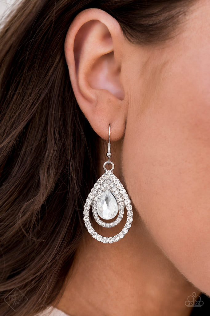 An oversized white teardrop gem is nestled inside two expansive teardrop frames encrusted in dainty white rhinestones, creating a rippling radiance. Earring attaches to a standard fishhook fitting.  Sold as one pair of earrings.  