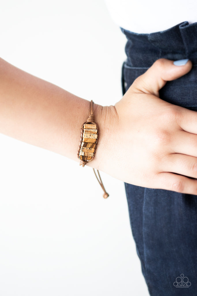 Chiseled into tranquil rectangular shapes, a colorful row of natural stones are knotted in place around the wrist with a piece of brown cording for an earthy look. As the stone elements in this piece are natural, some color variation is normal. Features an adjustable sliding knot closure.  Sold as one individual bracelet.