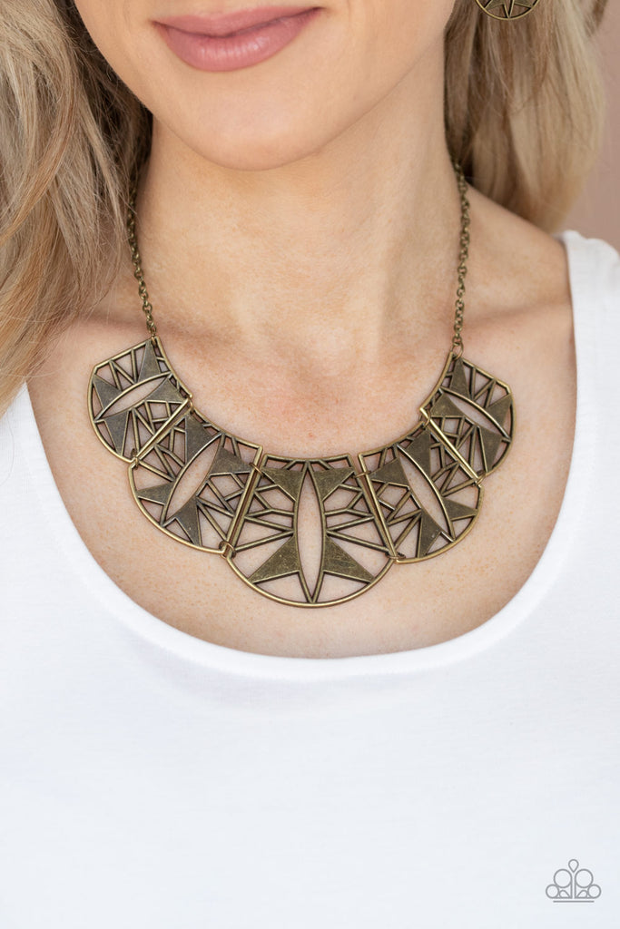 Radiating with striking geometric details, asymmetrical brass plates gradually increase in size as they link below the collar for a statement-making fashion. Features an adjustable clasp closure.  Sold as one individual necklace. Includes one pair of matching earrings.