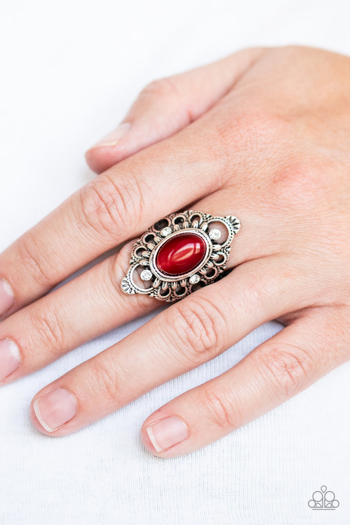 A glowing red cat's eye stone nestles inside of a frilly floral frame dotted with dainty white rhinestones and delicate antiqued details. Features a stretchy band for a flexible fit.  Sold as one individual ring.