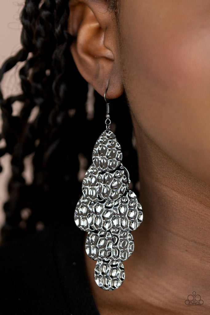 Featuring metallic honeycomb-like patterns, glistening gunmetal teardrop frames cascade from the ear, coalescing into a noise-making lure. Earring attaches to a standard fishhook fitting.  Sold as one pair of earrings.