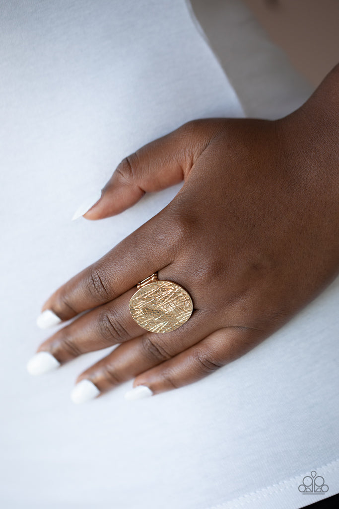 An oversized gold disc is etched in crisscrossing textures and hammered into light-catching ripples as it sits atop the finger unapologetically. Features a stretchy band for a flexible fit.  Sold as one individual ring.