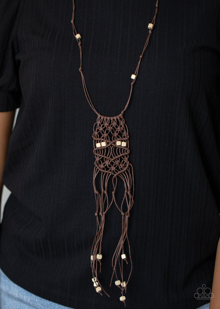 A collection of square wooden beads are knotted in place along strands of shiny brown cording, adding an earthy flair to the whimsically tasseled macramé pendant at the bottom of the elegantly lengthened display. Features an adjustable sliding knot closure.  Sold as one individual necklace. Includes one pair of matching earrings.