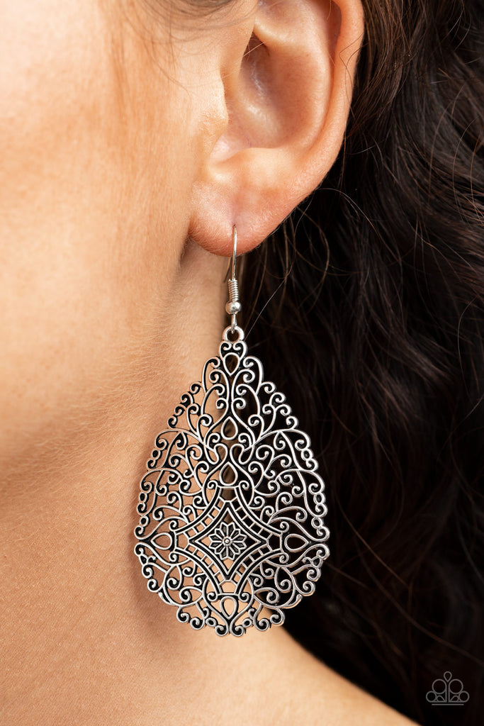 Brushed in an antiqued finish, burnished silver filigree climbs into a floral teardrop frame for a whimsically vintage look. Earring attaches to a standard fishhook fitting.  Sold as one pair of earrings.