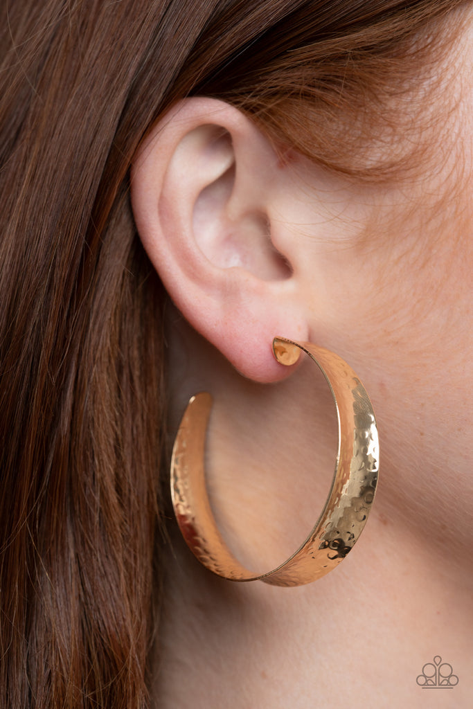 Featuring a beveled surface, a hammered gold bar delicately curls into an edgy hoop. Earring attaches to a standard post fitting. Hoop measures approximately 2" in diameter.  Sold as one pair of hoop earrings.  