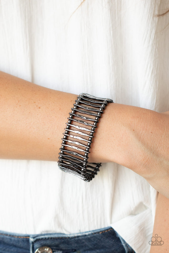 Separated by dainty gunmetal beads, hammered gunmetal bars are threaded along stretchy bands around the wrist for an edgy display.  Sold as one individual bracelet.