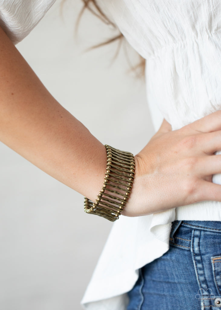 Separated by dainty brass beads, hammered brass bars are threaded along stretchy bands around the wrist for an edgy rustic display.  Sold as one individual bracelet.