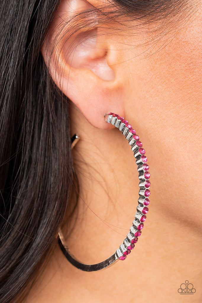 The front half of a glistening silver hoop is encrusted in a glassy row of dainty pink rhinestones for a glamorously timeless finish. Earring attaches to a standard post fitting. Hoop measures approximately 2 1/2" in diameter.  Sold as one pair of hoop earrings.  