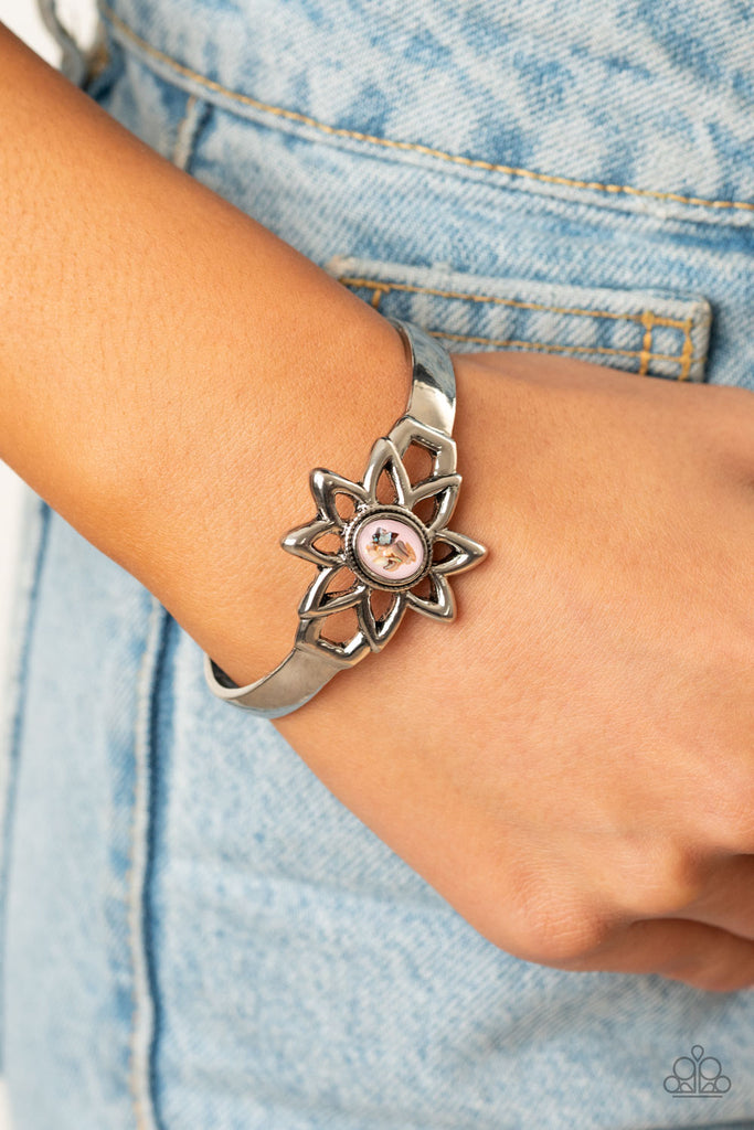 Flecked in shell-like shimmer, a glassy pink stone bead is pressed into the center of a shiny silver daisy frame that sits atop a dainty silver cuff for a seasonal flair.  Sold as one individual bracelet.
