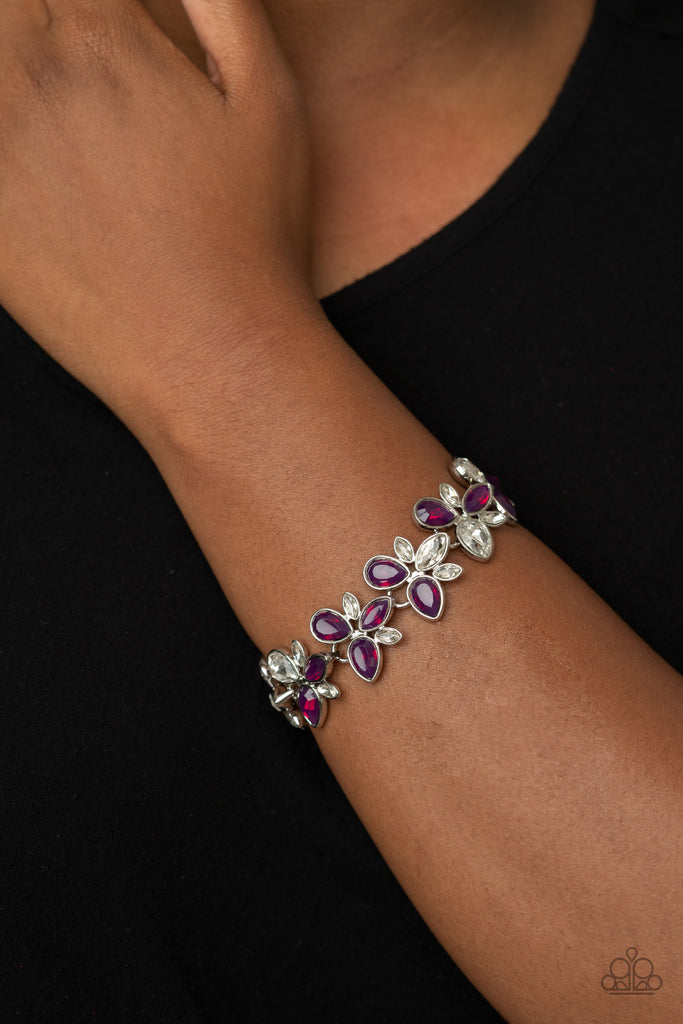 A glittery collection of Magenta Purple and glassy white teardrop rhinestones delicately connect into colorful frames around the wrist for an icy iridescence. Features an adjustable clasp closure.  Sold as one individual bracelet.