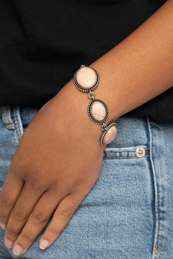 A collection of earthy brown oval stones are pressed into studded silver frames that delicately link across the wrist for a colorfully rustic look. Features an adjustable clasp closure.  Sold as one individual bracelet.