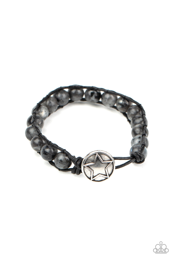 Infused with a decorative silver star embossed button, speckled black stones are threaded in place between two dainty black cords around the wrist for a seasonal fashion. Features a button loop closure.  Sold as one individual bracelet.  