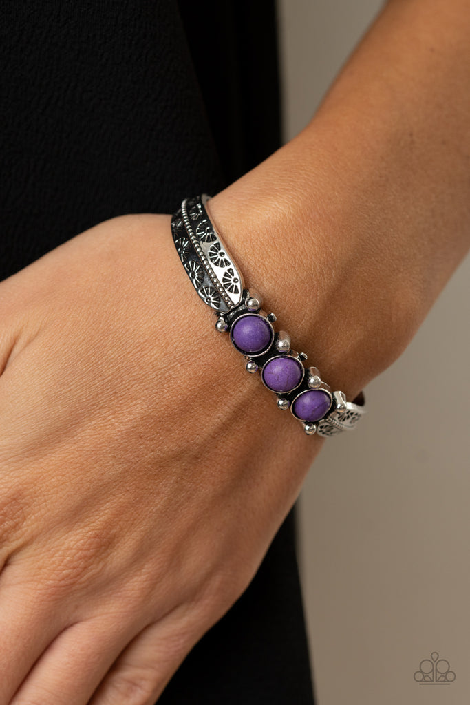 A trio of vivacious purple stones are encrusted along the center of a dainty silver studded cuff stamped in tribal inspired details for a seasonal flair.  Sold as one individual bracelet.  