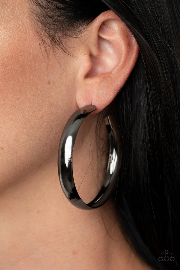 A thick gunmetal bar dramatically curls into an oversized hoop for a classic look. Earring attaches to a standard post fitting. Hoop measures approximately 2 1/2" in diameter.  Sold as one pair of hoop earrings.