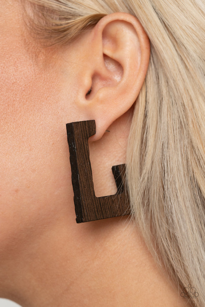 Brushed in a neutral brown finish, a distressed wooden frame curves around the ear, creating a rectangular hoop for a retro effect. Earring attaches to a standard post fitting. Hoop measures approximately 1" in diameter.  Sold as one pair of hoop earrings.