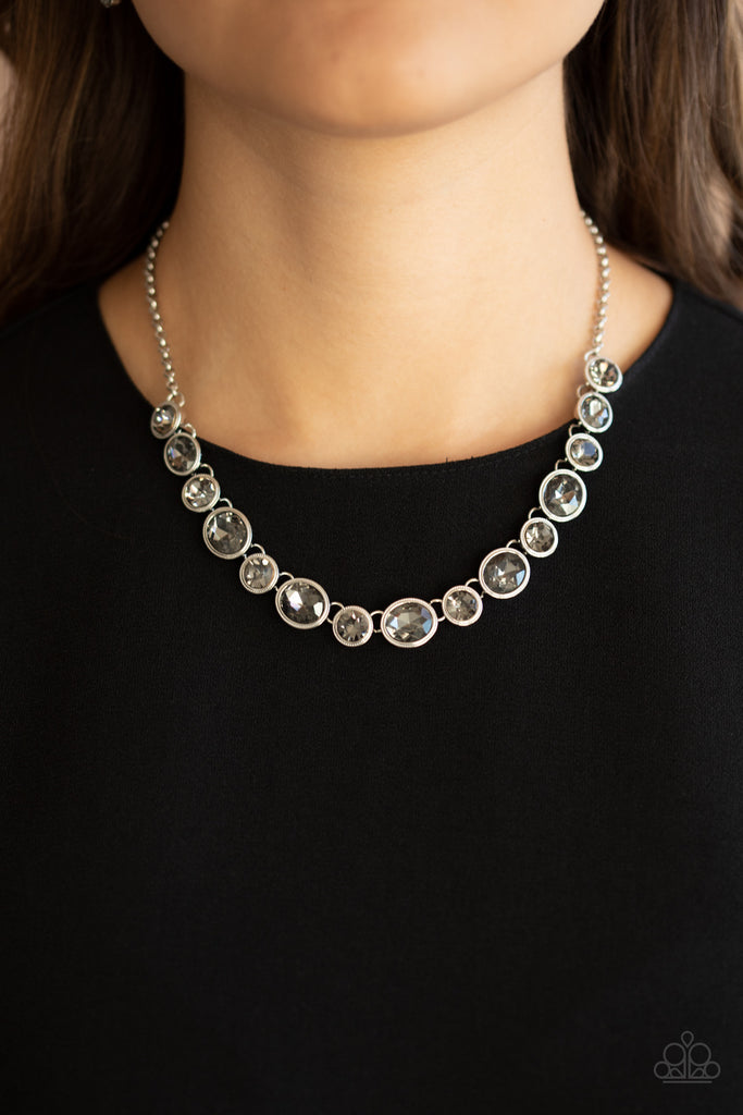 Encased in sleek silver frames, oval and round smoky rhinestones alternate below the collar for a timeless look. Features an adjustable clasp closure.  Sold as one individual necklace. Includes one pair of matching earrings.