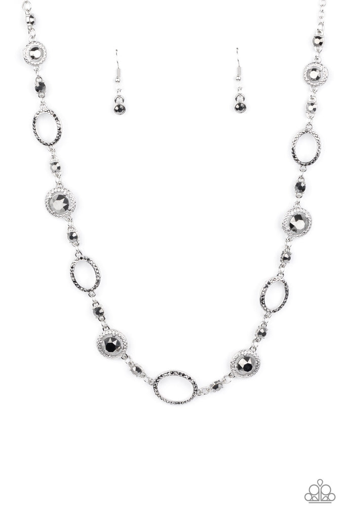 A mismatched collection of hematite rhinestone encrusted silver ovals and hematite rhinestone encrusted studded silver frames elegantly link across the chest for a refined flair. Features an adjustable clasp closure.  Sold as one individual necklace. Includes one pair of matching earrings.