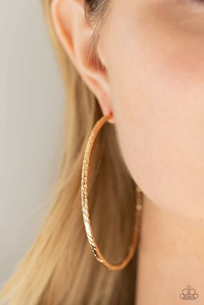 Etched in twisted diamond-cut texture, an oversized gold bar delicately curls into a dramatically oversized hoop. Earring attaches to a standard post fitting. Hoop measures approximately 2 1/2" in diameter.  Sold as one pair of hoop earrings.