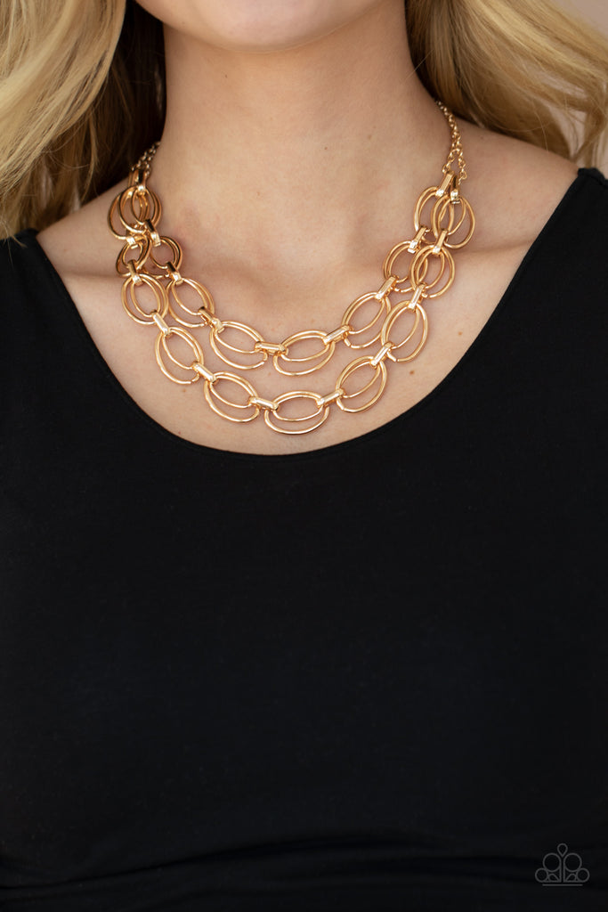 Varying in size, pairs of gold oval links connect into two bold layers below the collar for a gritty industrial look. Features an adjustable clasp closure.  Sold as one individual necklace. Includes one pair of matching earrings.  New Kit