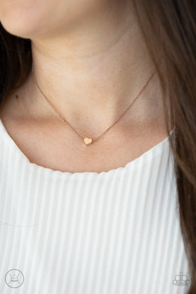 A dainty rose gold heart bead glides along a dainty rose gold ball chain, creating a flirty pendant around the neck. Features an adjustable clasp closure.  Sold as one individual choker necklace. Includes one pair of matching earrings.  