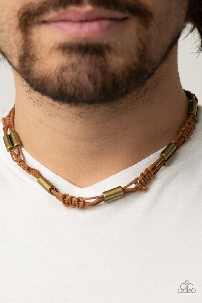 Bold brass accents are knotted in place along tan cording that decoratively braids around the neck for a rustic flair. Features an adjustable sliding knot closure.  Sold as one individual necklace. Includes one pair of matching earrings.