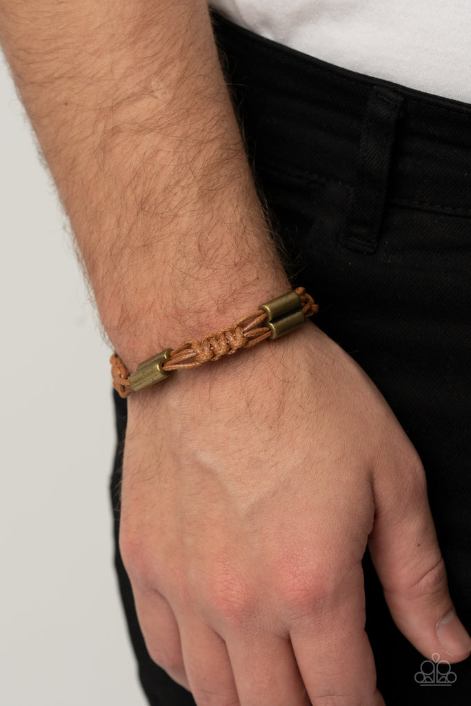 Bold brass accents are knotted in place along tan cording that decoratively braids around the wrist for a rustic flair. Features an adjustable sliding knot closure.  Sold as one individual bracelet.