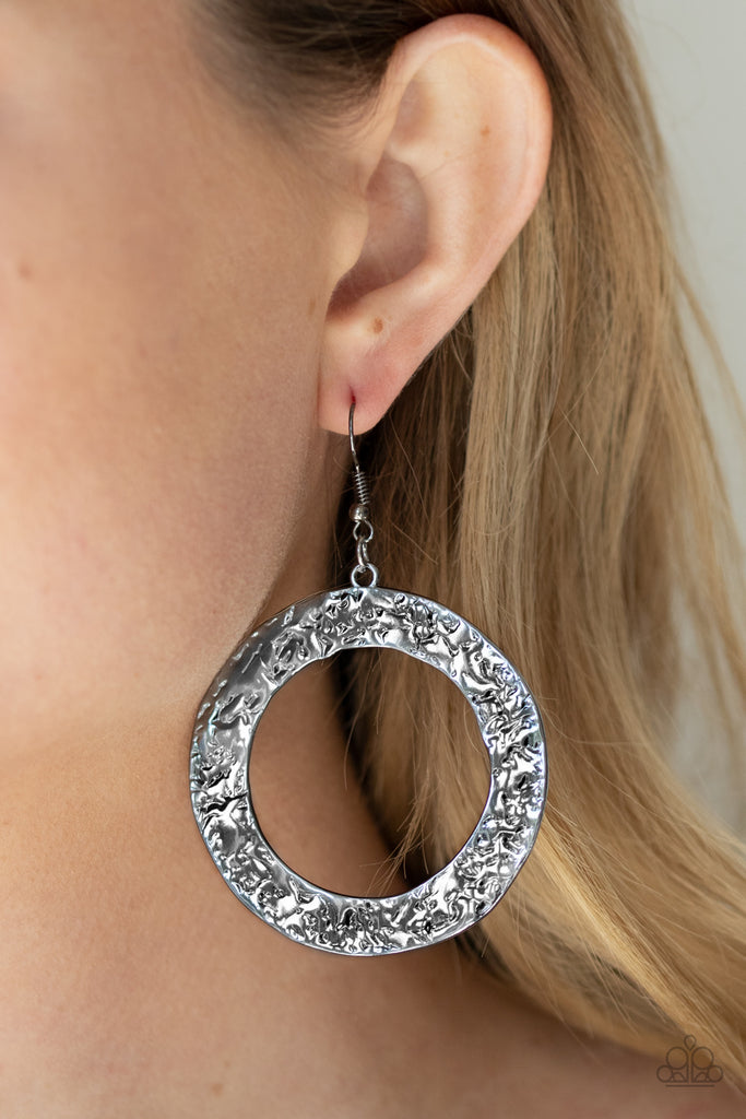 A flat gunmetal circular frame has been hammered in blinding detail for a handcrafted look. Earring attaches to a standard fishhook fitting.  Sold as one pair of earrings.  