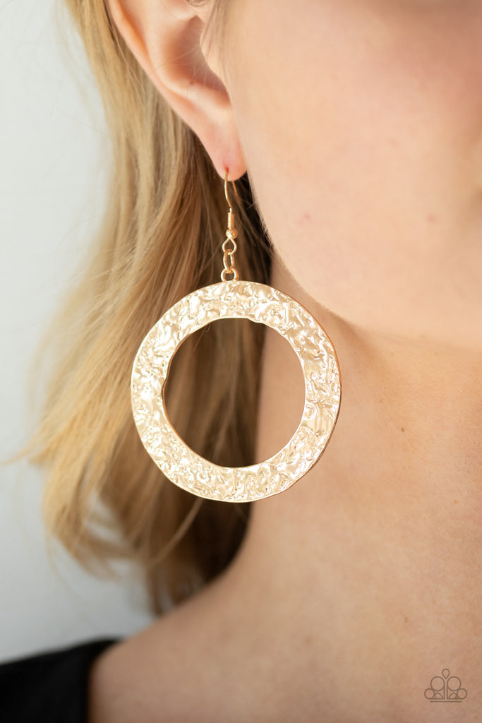 A flat gold circular frame has been hammered in blinding detail for a handcrafted look. Earring attaches to a standard fishhook fitting.  Sold as one pair of earrings.