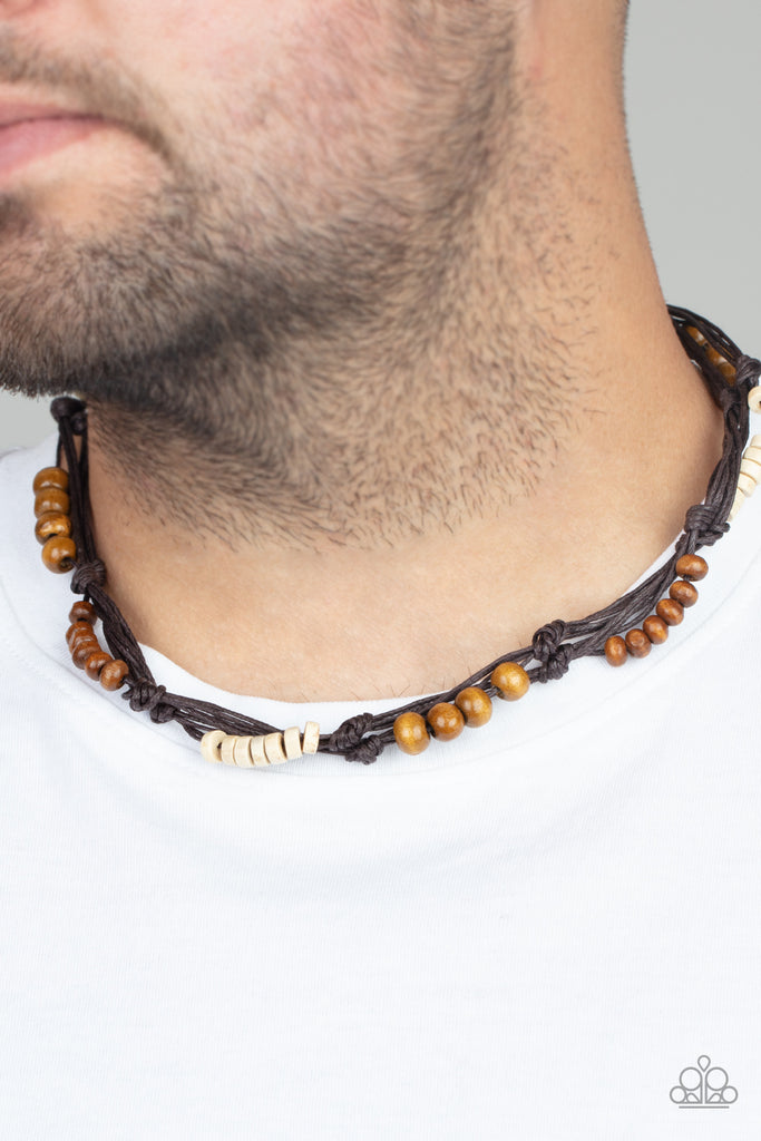 Featuring round and disc shapes, mismatched sections of brown and white wooden beads are knotted along strands of brown cording that loop around the neck for an island inspired look. Features a button loop closure.  Sold as one individual necklace.  