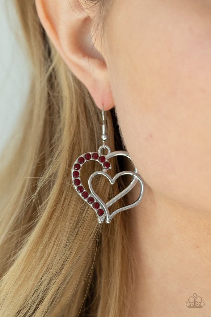 Two shimmery silver hearts delicately overlap into a romantic frame. The edge of the largest heart is encrusted in a section of fiery red rhinestones for a colorfully charming finish. Earring attaches to a standard fishhook fitting.  Sold as one pair of earrings.