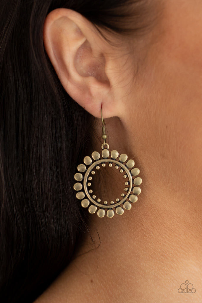 Asymmetrical brass discs flare out from an antiqued brass ring featuring an airy brass studded center, creating a radiant hoop. Earring attaches to a standard fishhook fitting.  Sold as one pair of earrings.