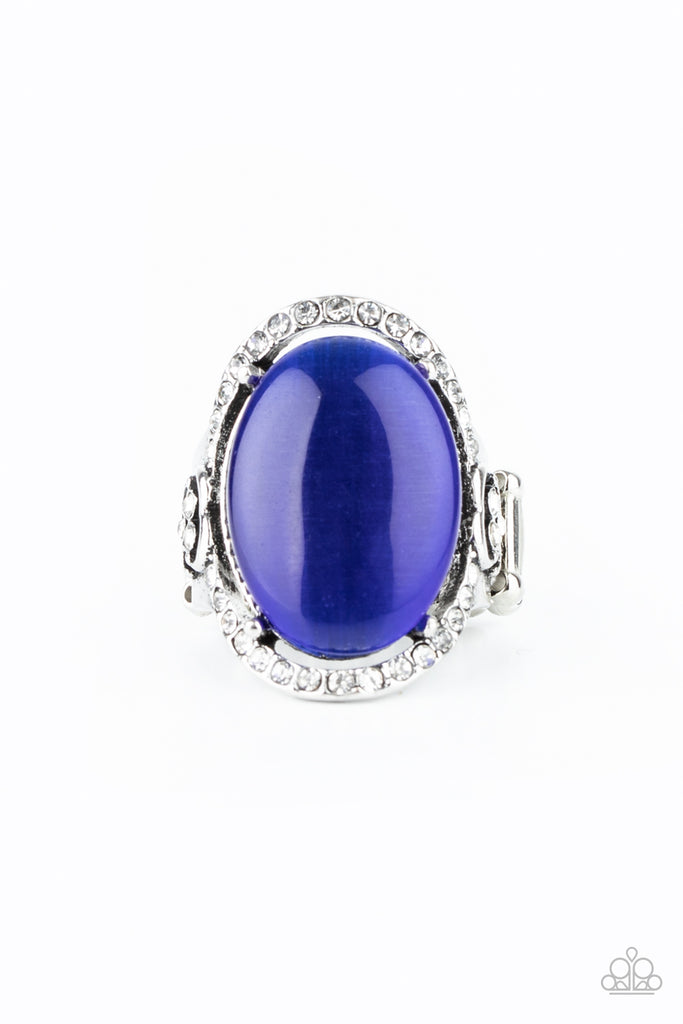 An oval blue cat's eye stone is nestled inside a ring of white rhinestones featuring dainty heart details, creating a charming centerpiece atop the finger. Features a stretchy band for a flexible fit.  Sold as one individual ring.