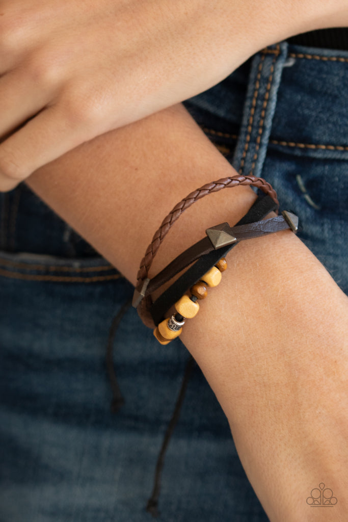 Infused with mismatched metal and wooden accents, rows of black and brown suede and leather cords layer across the wrist for a rugged look. Features an adjustable sliding knot closure.  Sold as one individual bracelet.  