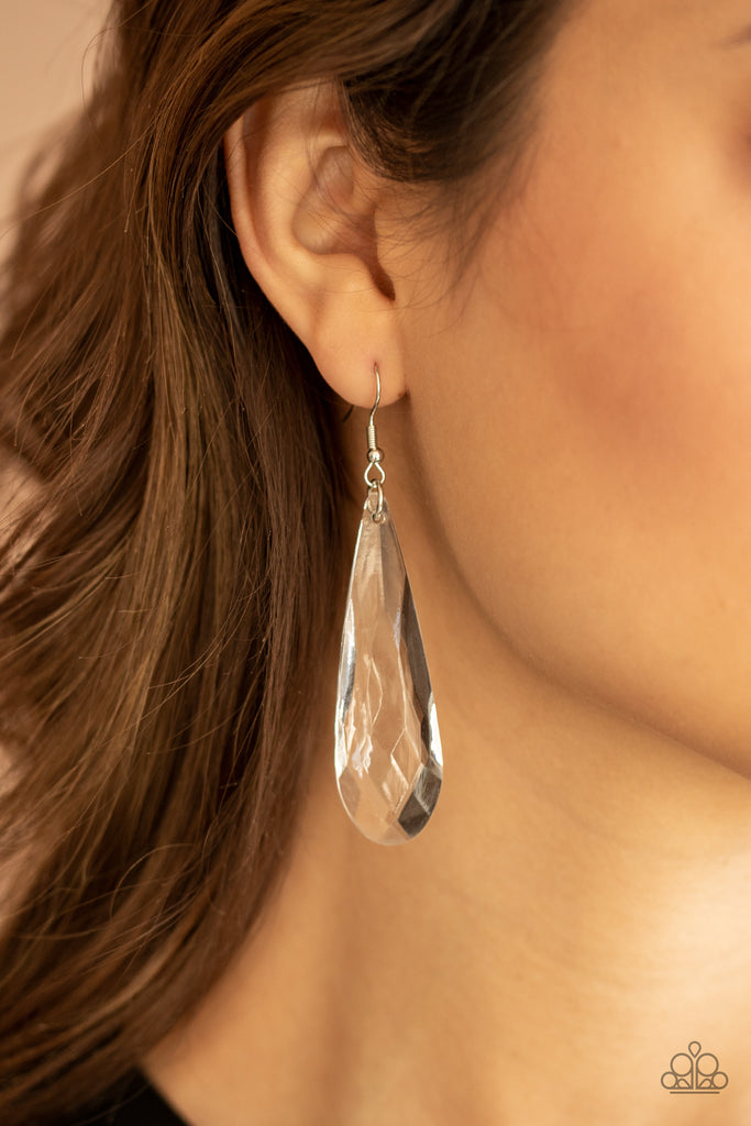 A dramatically oversized white teardrop crystal swings from the ear, creating an irresistible statement piece. Earring attaches to a standard fishhook fitting.  Sold as one pair of earrings.