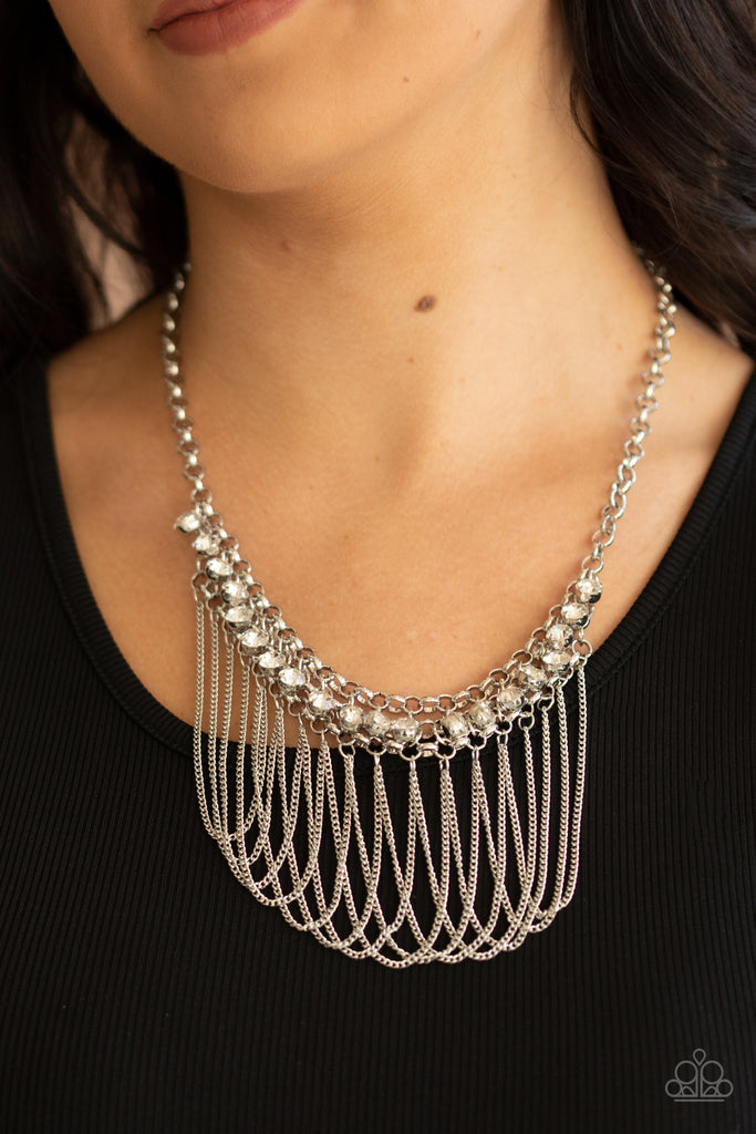 A sparkly series of glassy white rhinestones swings from the center of three interconnected rows of silver chains, creating an elegant mesh. Tiers of dainty silver chains drape into curtains of shimmer below the collar. Features an adjustable clasp closure.  Sold as one individual necklace. Includes one pair of matching earrings.