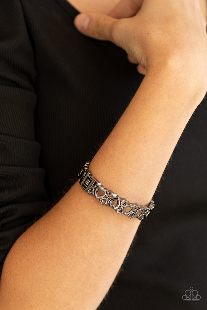 A charming collection of airy gunmetal heart frames connects into a dainty bangle-like cuff around the wrist. Features a hinged closure.  Sold as one individual bracelet.