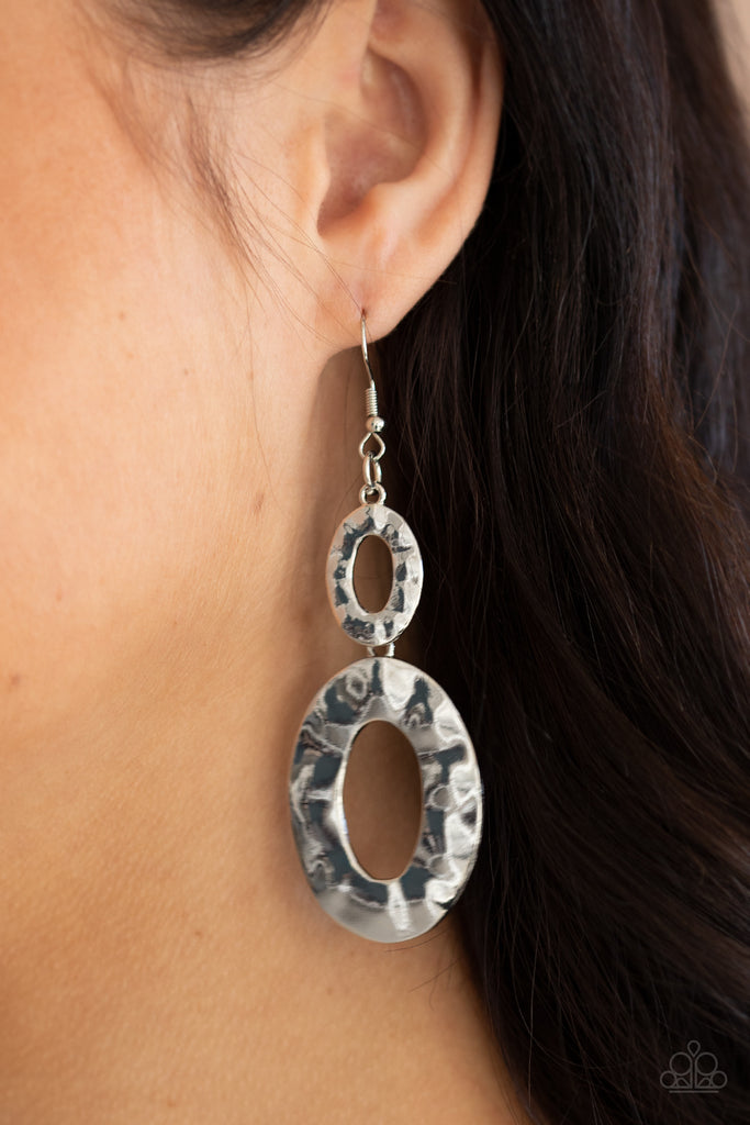 A mismatched pair of hammered silver ovals delicately link into a blinding metallic lure. Earring attaches to a standard fishhook fitting.  Sold as one pair of earrings.