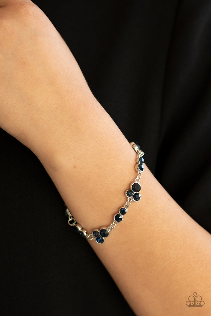Encased in sleek silver frames, dainty pairs and trios of glittery blue rhinestones delicately link into a timeless display around the wrist. Features an adjustable clasp closure.  Sold as one individual bracelet.