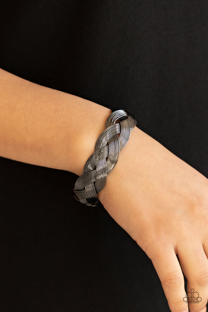Attached to two glistening gunmetal fittings, rows of dainty gunmetal wires weave around the wrist, creating a boldly braided cuff.  Sold as one individual bracelet.  