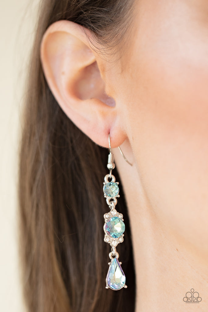 Featuring a white rhinestone encrusted frame, an oversized blue rhinestone is linked between a classic round and teardrop blue rhinestone for an elegantly stacked look. Earring attaches to a standard fishhook fitting.  Sold as one pair of earrings.